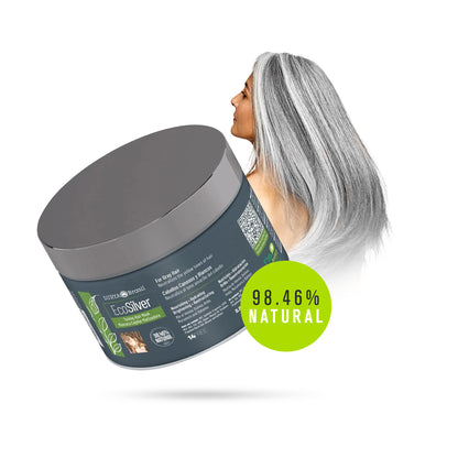 A woman with grey hair holding a round container of EcoSilver Toning Hair Mask. Enriched with Henna, Quinoa, and Amla for nourishment and strength, it neutralizes yellow tones in gray hair.