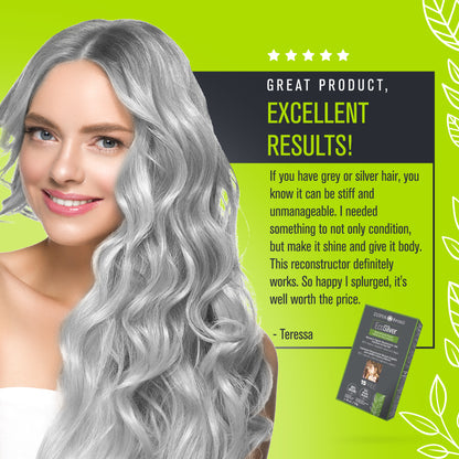 A woman with long grey hair smiling, holding a box of EcoSilver Henna Powder. Vegan reconstructive treatment for gray hair, enriched with Brazilian plants and oils for deep hydration and hair repair.